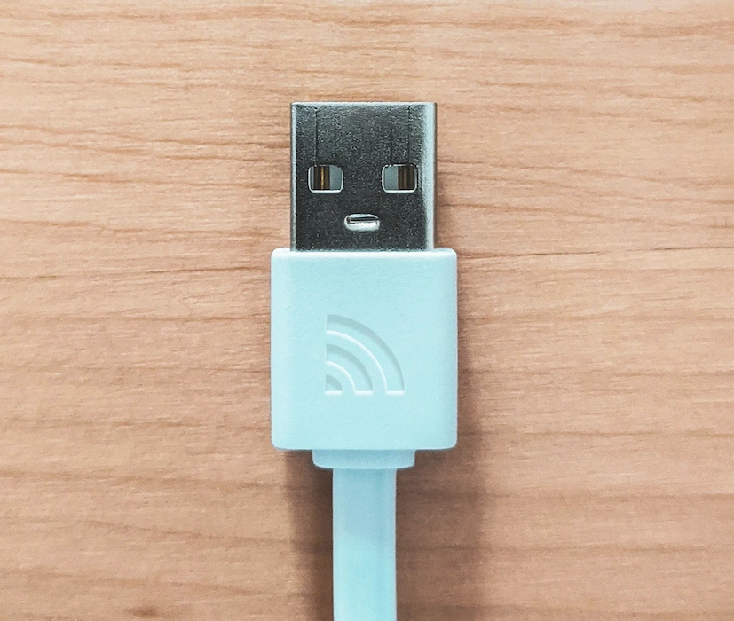 USB Kabel auf Holz mit TBF-IT Logo